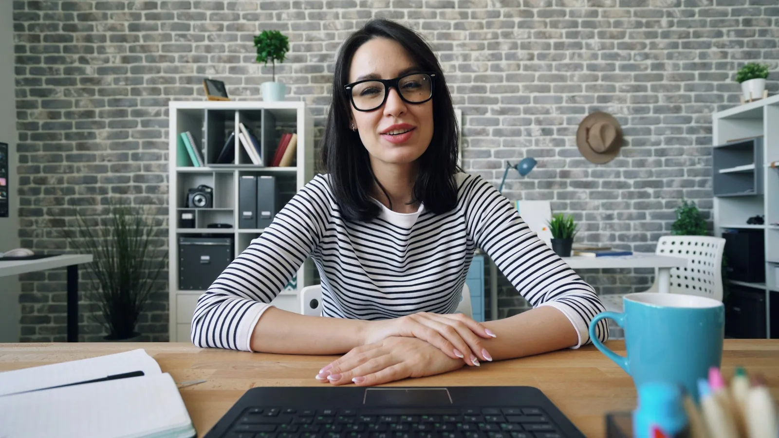 A woman talking on a video call at her desk in an office