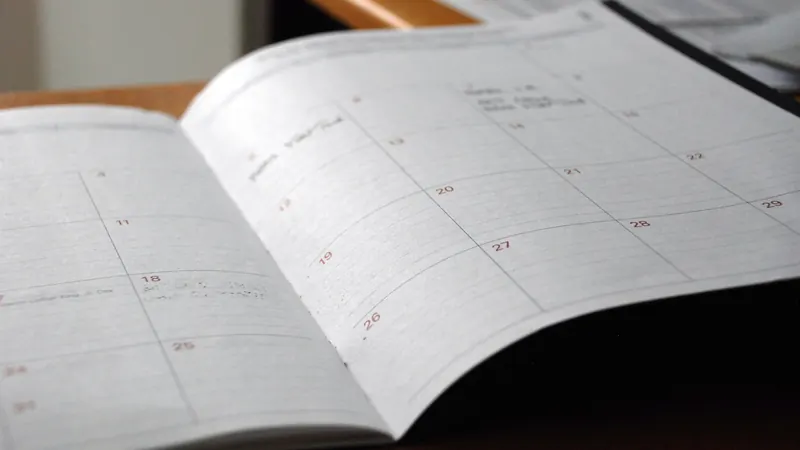 An open monthly planner on a wooden desk